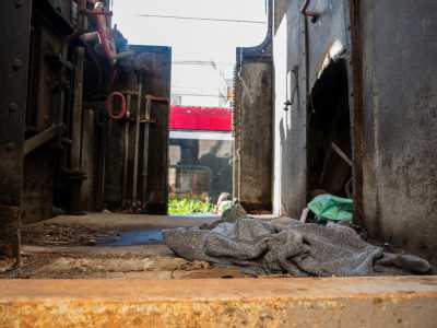 Per terra in un angolo troviamo maglioni e coperte consunte, tracce di clochard che probabilmente hanno trovato qui una precaria dimora